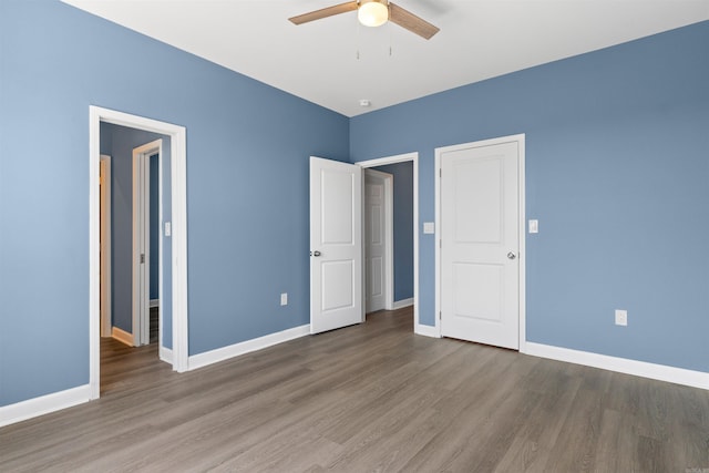 8010 Kanis Oaks Dr, Little Rock, AR 72204 - unfurnished bedroom with baseboards, a ceiling fan, and wood finished floors