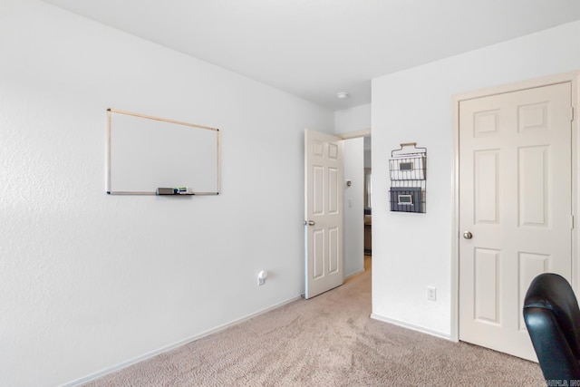 bedroom featuring light colored carpet and baseboards