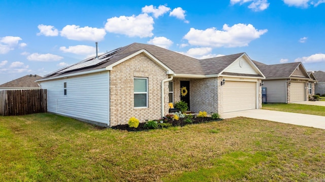 ranch-style house featuring a garage, fence, a front lawn, solar panels, and driveway