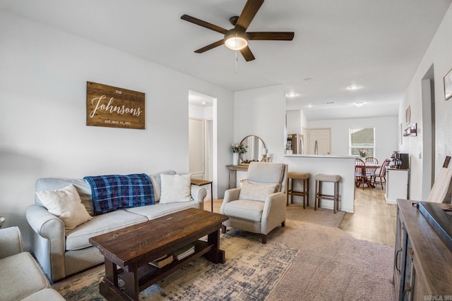 living room with light wood-style floors and a ceiling fan