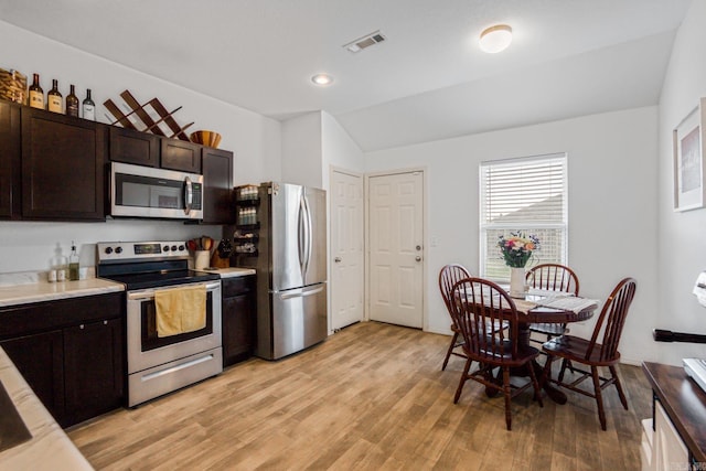 kitchen featuring dark brown cabinetry, light wood-type flooring, visible vents, light countertops, and stainless steel appliances