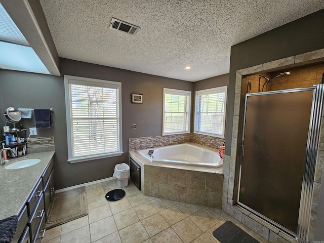 bathroom featuring plenty of natural light, tile patterned floors, visible vents, and a garden tub