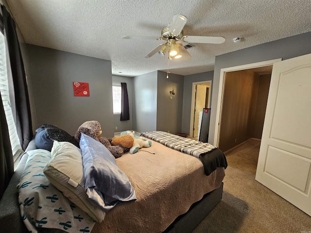 bedroom with visible vents, ceiling fan, carpet flooring, and a textured ceiling