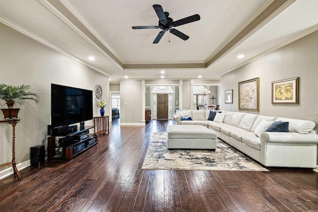living room featuring baseboards, ornamental molding, a raised ceiling, ceiling fan, and wood-type flooring