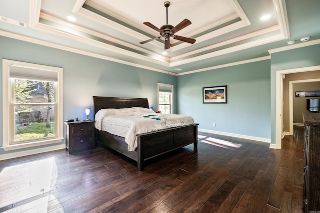 bedroom with a raised ceiling, crown molding, dark wood finished floors, and visible vents