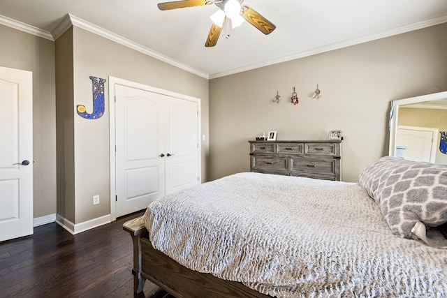 bedroom with a closet, dark wood-style floors, baseboards, and crown molding