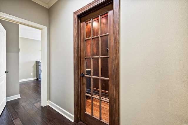 hallway featuring crown molding, baseboards, and dark wood-style floors