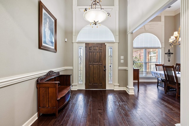 entrance foyer with baseboards, a towering ceiling, a chandelier, and hardwood / wood-style flooring