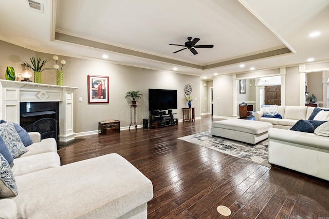 living room featuring recessed lighting, a tray ceiling, and ornamental molding