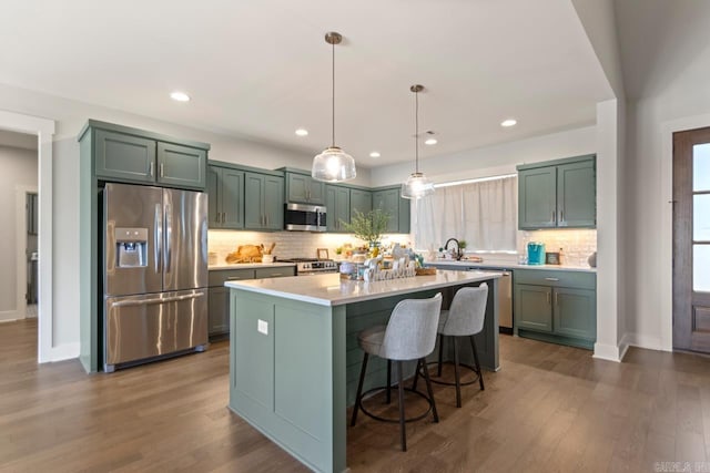 kitchen featuring backsplash, light countertops, dark wood finished floors, and stainless steel appliances