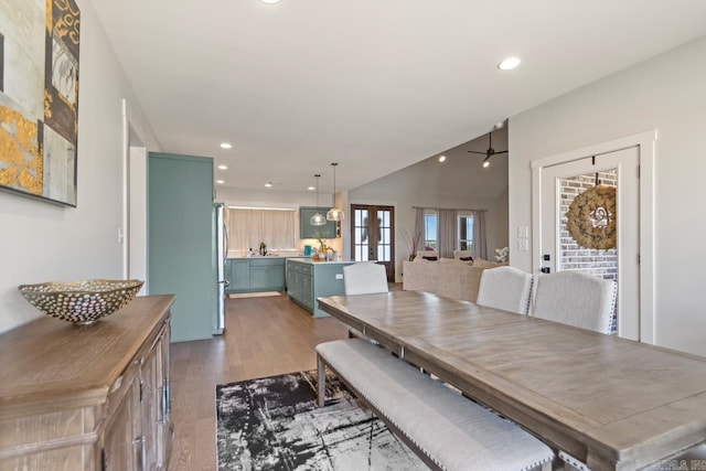 dining room featuring wood finished floors, a ceiling fan, vaulted ceiling, and recessed lighting