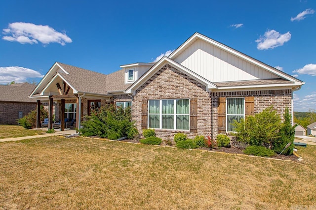 craftsman inspired home featuring roof with shingles, brick siding, and a front lawn