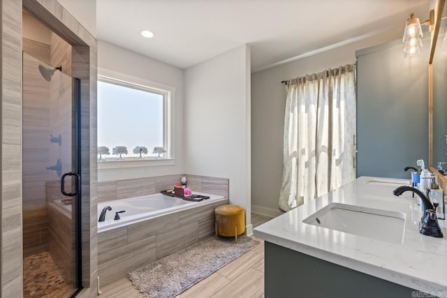 full bathroom featuring double vanity, a bath, a sink, and a stall shower