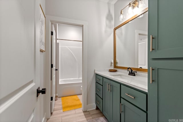 full bath with wood finished floors, vanity, and shower / washtub combination