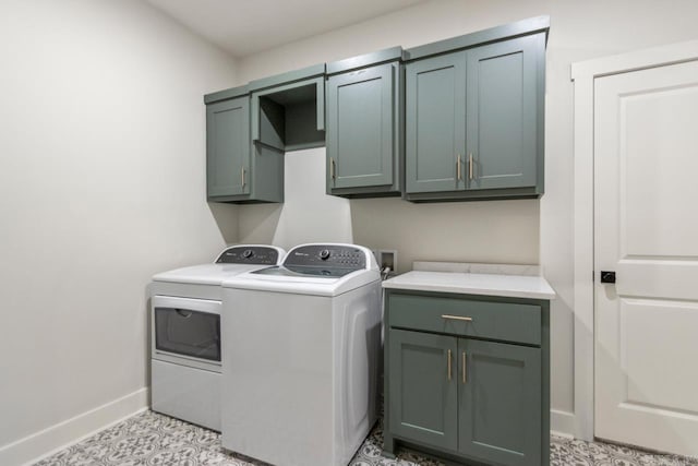 clothes washing area featuring independent washer and dryer, baseboards, and cabinet space