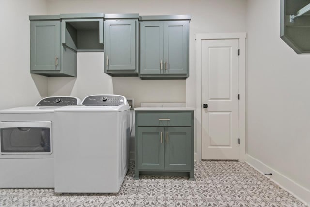 washroom with washing machine and clothes dryer, baseboards, and cabinet space