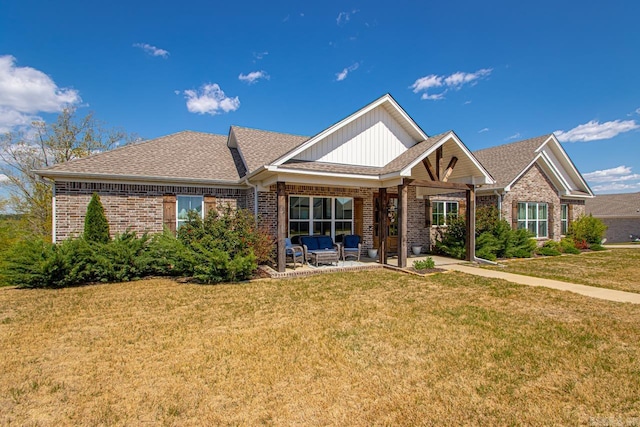single story home featuring a patio area, brick siding, a shingled roof, and a front yard