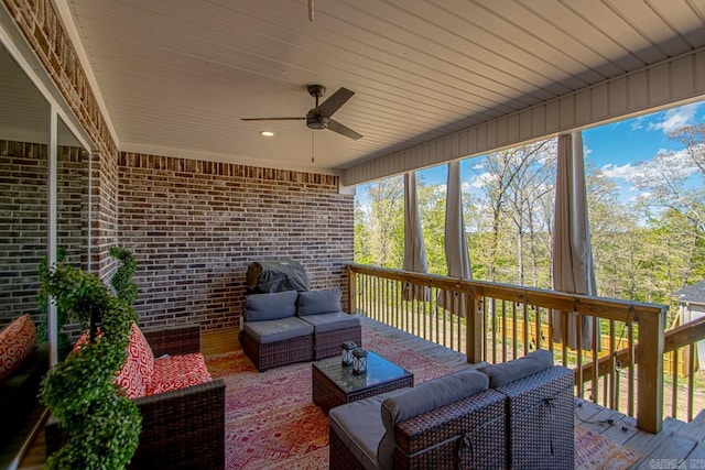 wooden terrace with an outdoor living space and ceiling fan