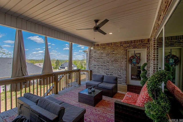 wooden terrace with an outdoor hangout area and ceiling fan