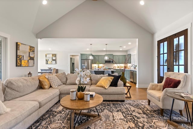 living room featuring french doors, high vaulted ceiling, recessed lighting, and wood finished floors