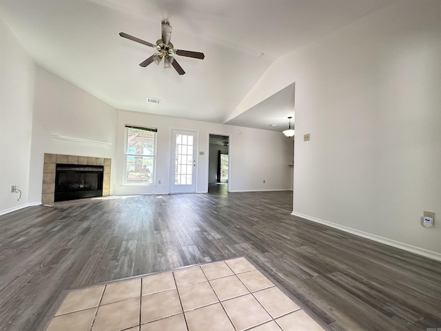 3 Park Ridge Dr, Maumelle, AR 72113 - unfurnished living room featuring ceiling fan, vaulted ceiling, wood finished floors, a tile fireplace, and baseboards