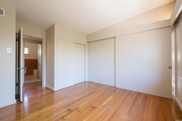unfurnished bedroom with a closet, light wood-style flooring, and visible vents