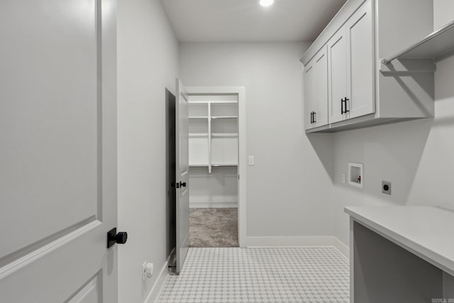 laundry area featuring electric dryer hookup, baseboards, tile patterned floors, washer hookup, and cabinet space