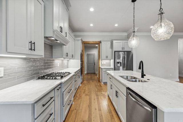 kitchen featuring a sink, a kitchen island with sink, crown molding, recessed lighting, and stainless steel appliances