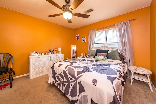 carpeted bedroom with visible vents and a ceiling fan