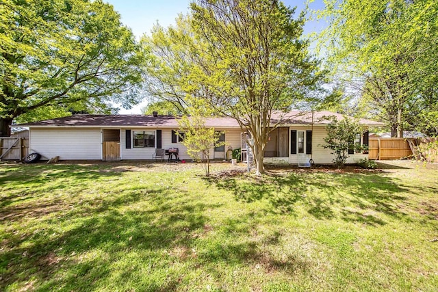 back of house featuring fence and a lawn