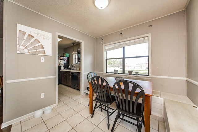 dining area featuring a textured ceiling, ornamental molding, and light tile patterned flooring