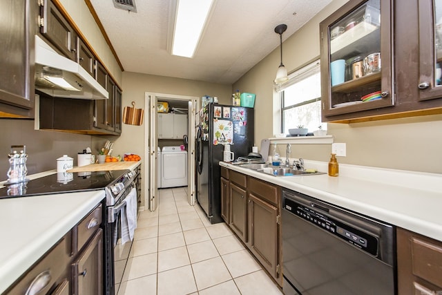 kitchen with black fridge, dishwasher, under cabinet range hood, stainless steel electric range, and washer / dryer