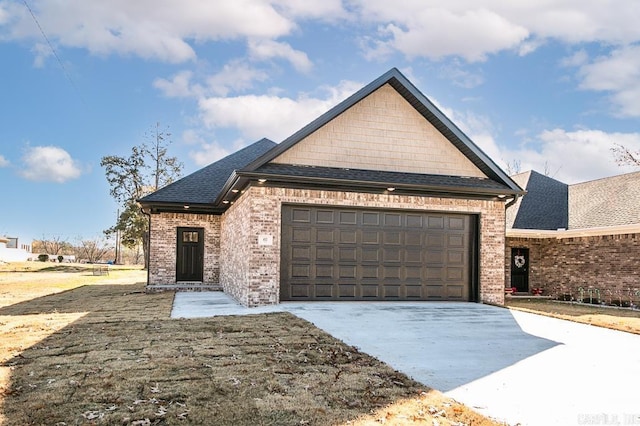 view of front of home with a shingled roof, concrete driveway, a garage, and brick siding