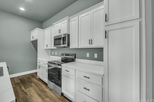 kitchen featuring white cabinetry, appliances with stainless steel finishes, baseboards, and dark wood-style floors