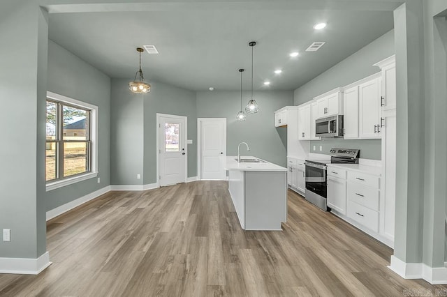 kitchen with baseboards, a sink, light countertops, appliances with stainless steel finishes, and light wood finished floors