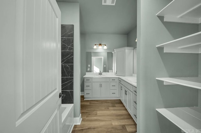 bathroom with visible vents, bathtub / shower combination, vanity, and wood finished floors