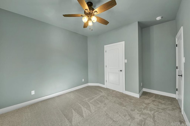 unfurnished room featuring baseboards, a ceiling fan, and carpet