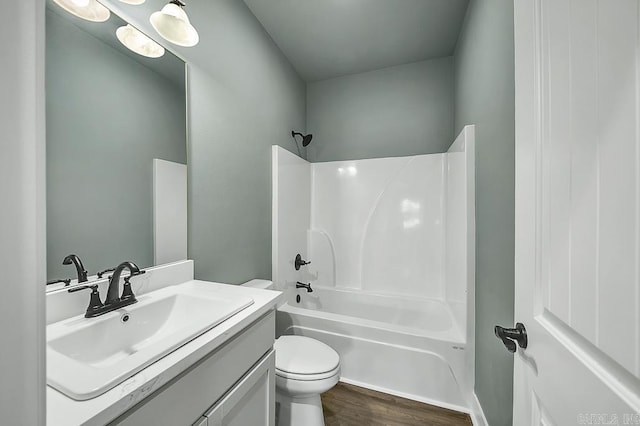 full bathroom featuring toilet, shower / bath combination, wood finished floors, and vanity