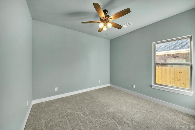 carpeted empty room featuring visible vents, baseboards, and ceiling fan