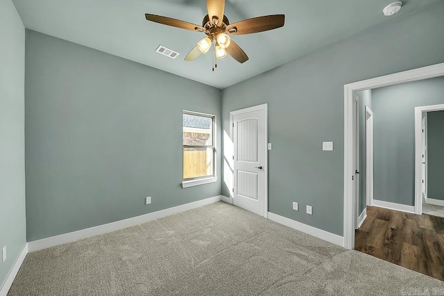 carpeted empty room featuring visible vents, baseboards, and a ceiling fan