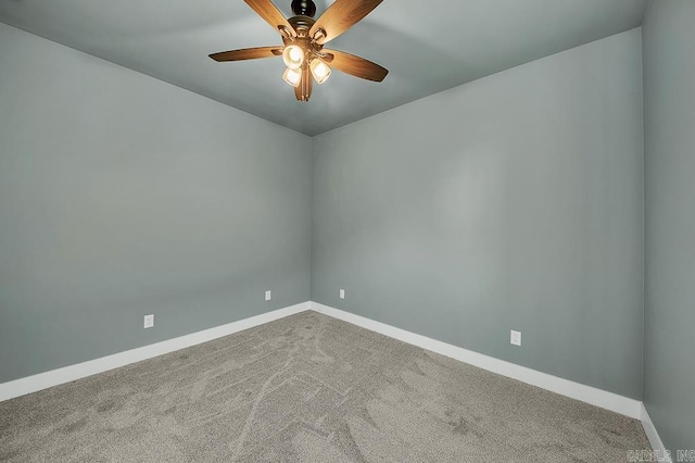 carpeted spare room featuring ceiling fan and baseboards