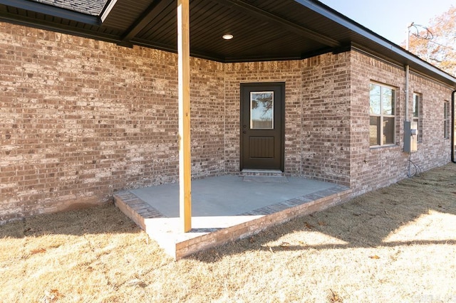 doorway to property with brick siding