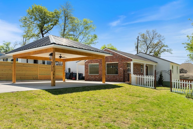 6723 Greenwood, Little Rock, AR 72207 - rear view of property featuring fence, brick siding, ceiling fan, a yard, and metal roof