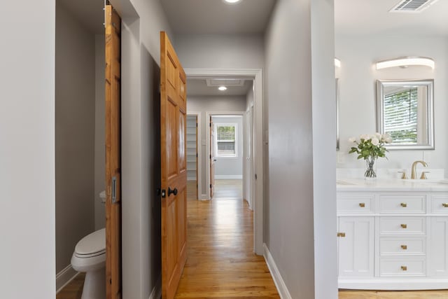 6723 Greenwood, Little Rock, AR 72207 - corridor featuring light wood-style floors, baseboards, a sink, and visible vents