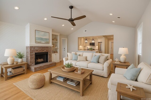 6723 Greenwood, Little Rock, AR 72207 - living room with ceiling fan, visible vents, vaulted ceiling, a brick fireplace, and light wood-style flooring