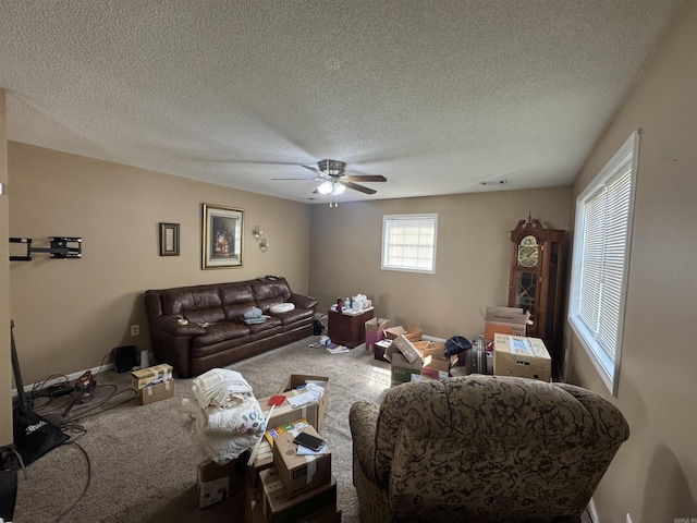 carpeted living room with ceiling fan and a textured ceiling