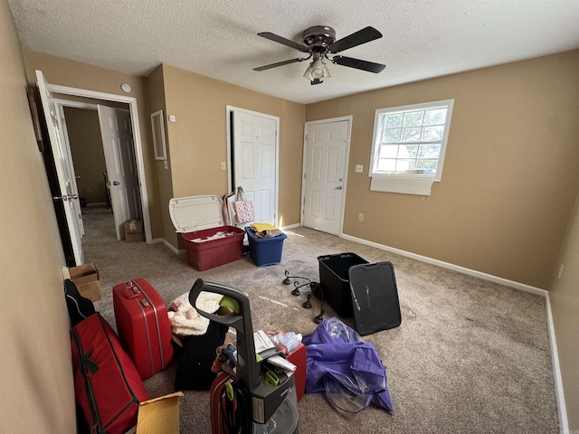 bedroom featuring a textured ceiling, a ceiling fan, carpet, and baseboards