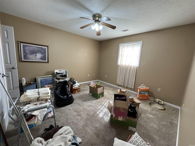bedroom with a textured ceiling, visible vents, carpet flooring, and baseboards