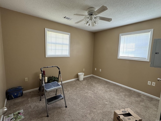 interior space with visible vents, ceiling fan, electric panel, and carpet flooring