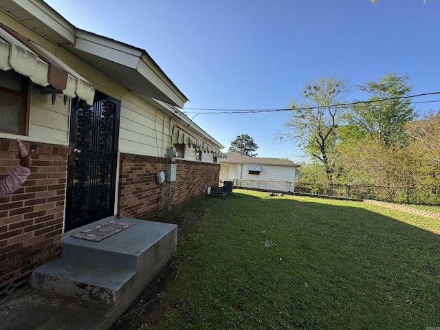 view of yard featuring fence and central air condition unit